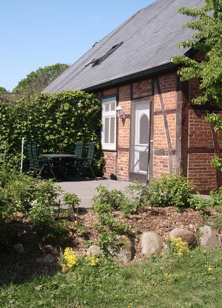 Aussenansicht der Ferienwohnung "Wildrose" auf dem Ferienhof Gauster im Wendland mit schöner Sonnenterasse und Gartenmöbeln.